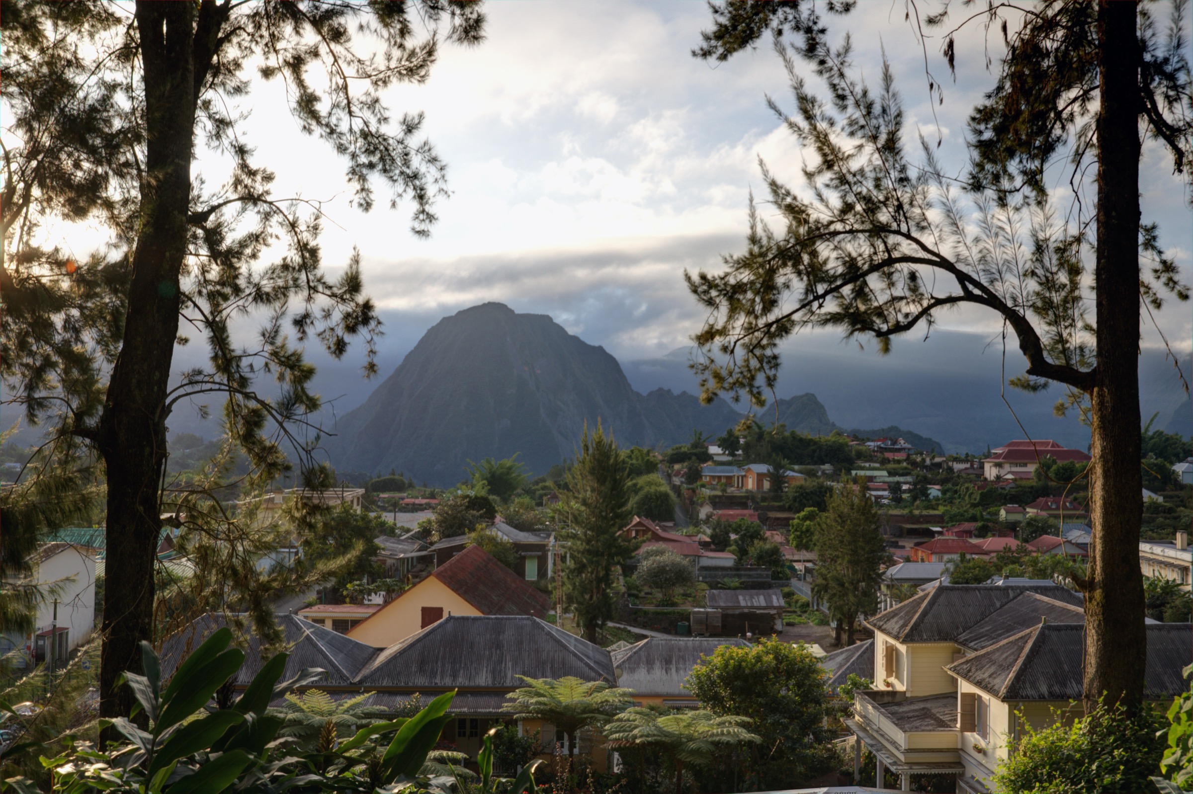 Coloured Creole houses and gardens in Hell-Bourg, with the Cirque de Salazie ramparts rising behind