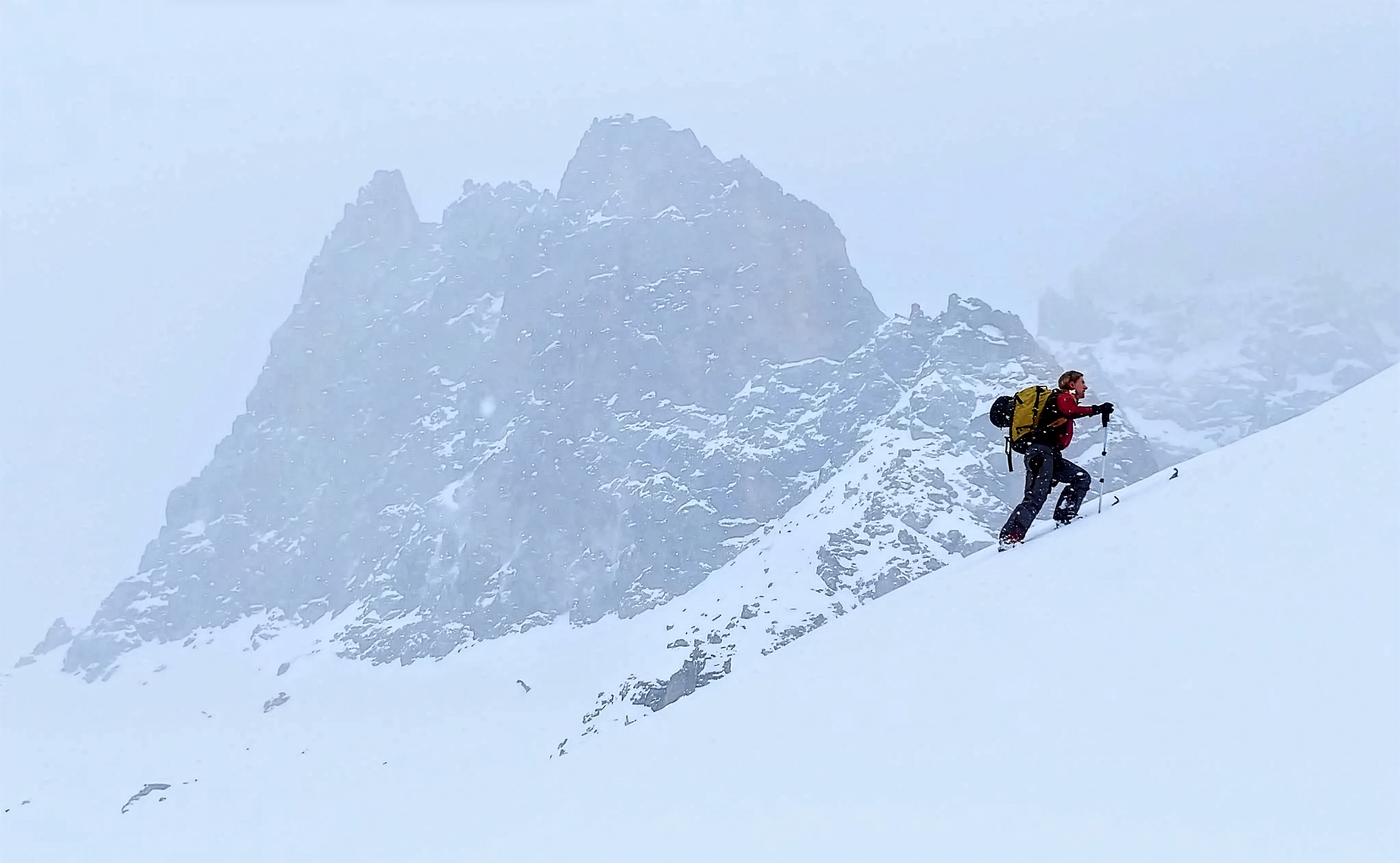 Ski mountaineer ascending a snow-covered peak