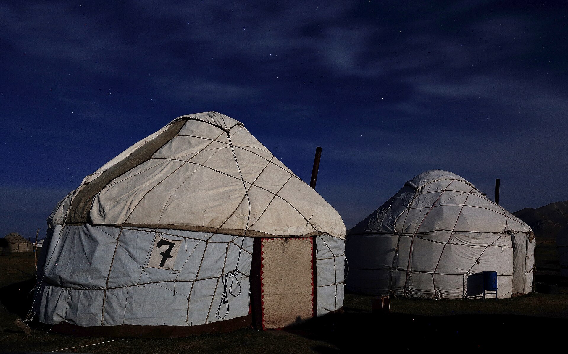 White yurts beneath stars and moonlight at Song-Kul