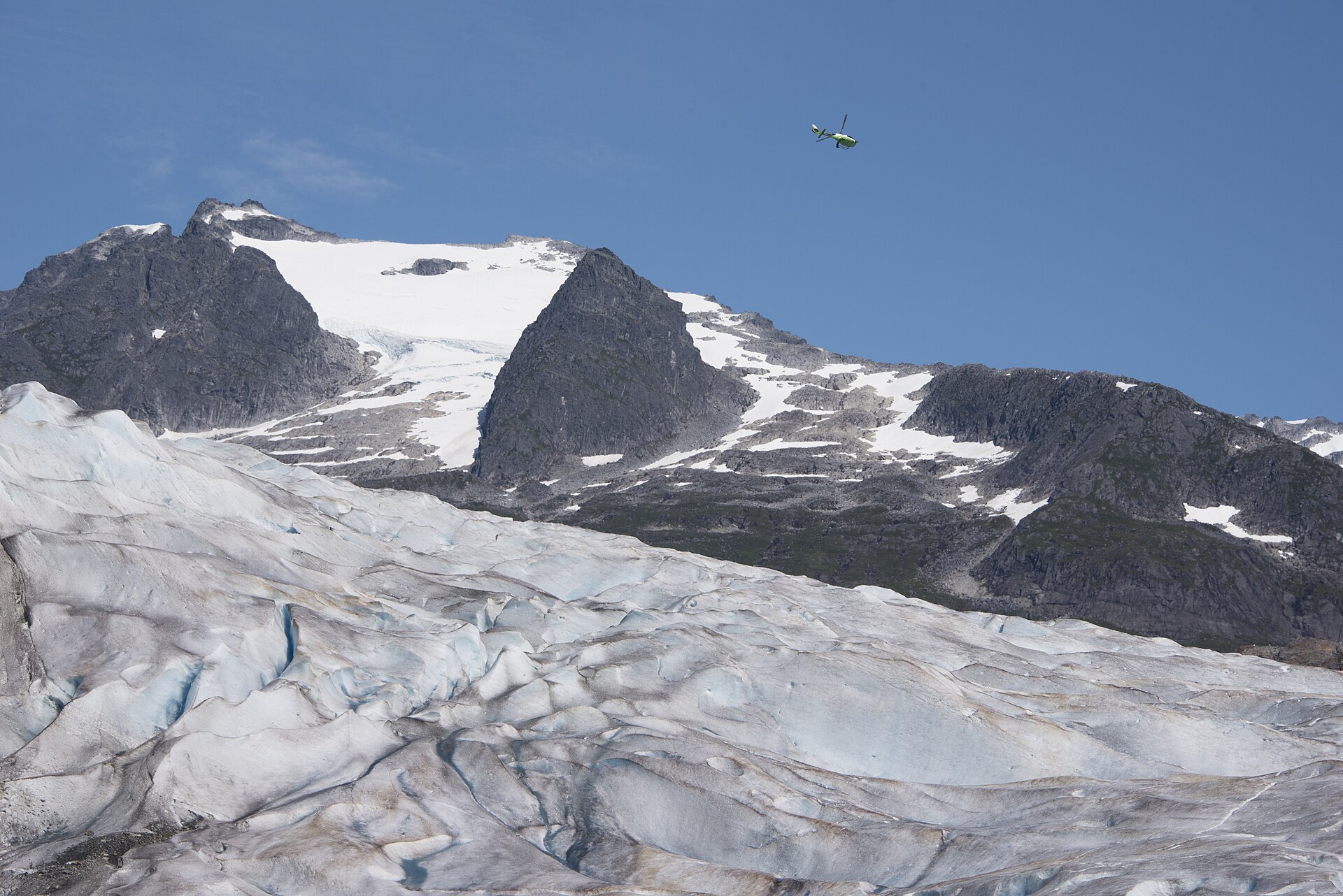 A small sightseeing helicopter turning above Mendenhall Glacier near Juneau