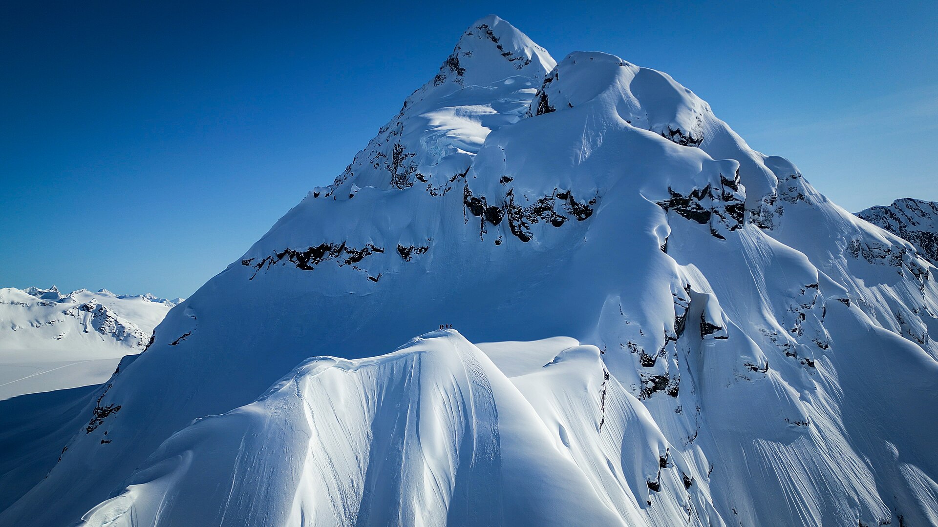 A sculpted snow peak above Valdez under a clear blue sky