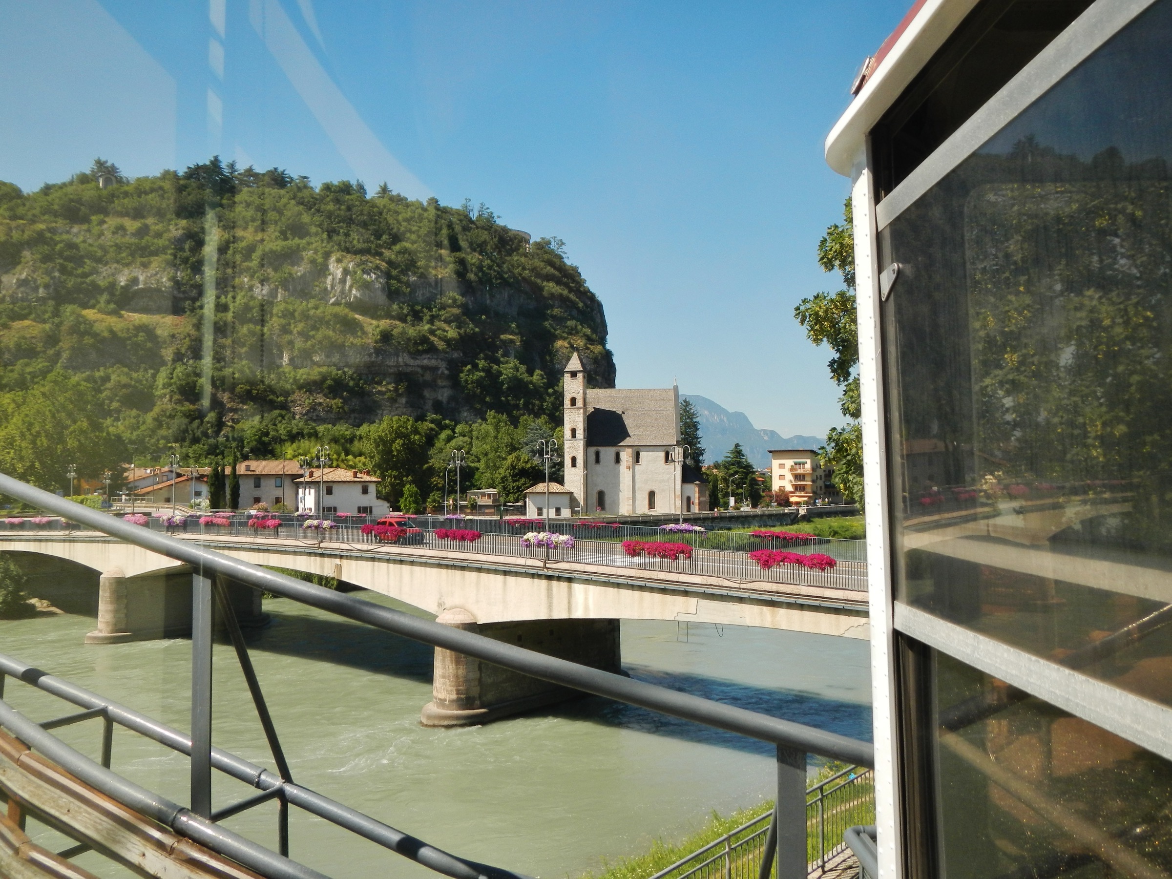 The Trento–Sardagna cable car rising above the Adige river with the San Lorenzo bridge and city rooftops below