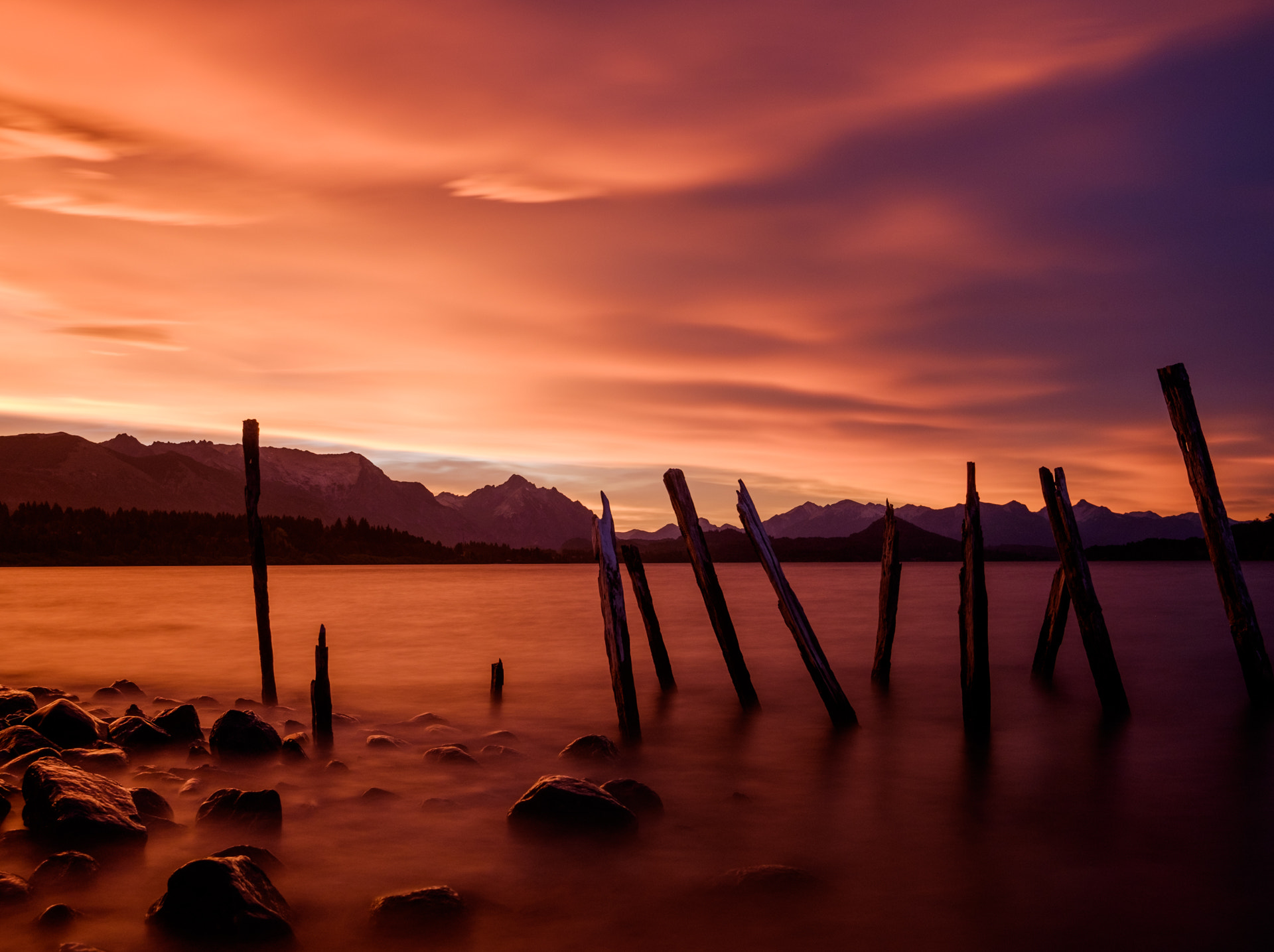 A vivid orange and purple sunset over Nahuel Huapi Lake and mountain silhouettes