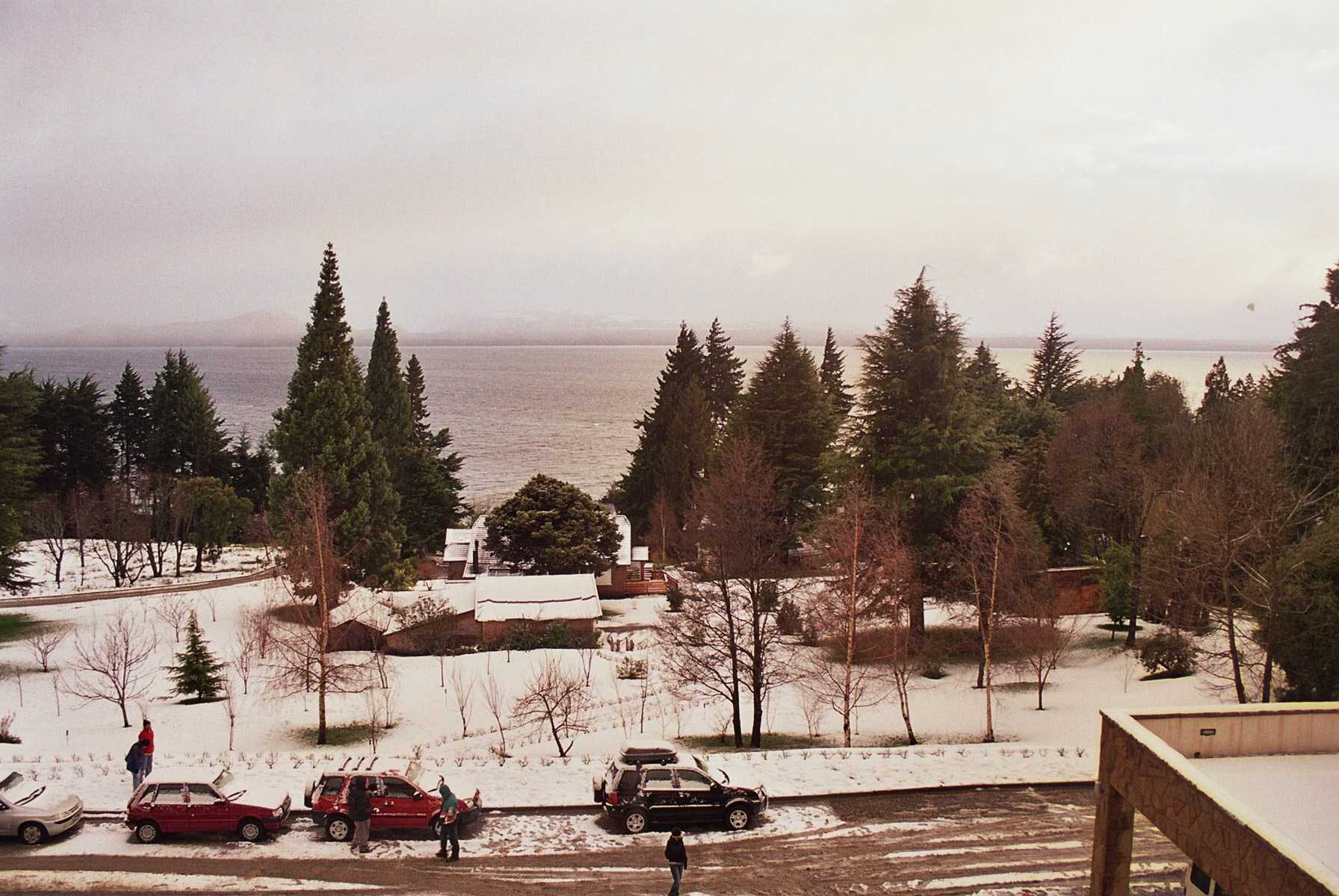 Snow-covered trees and houses beside Nahuel Huapi Lake in Bariloche