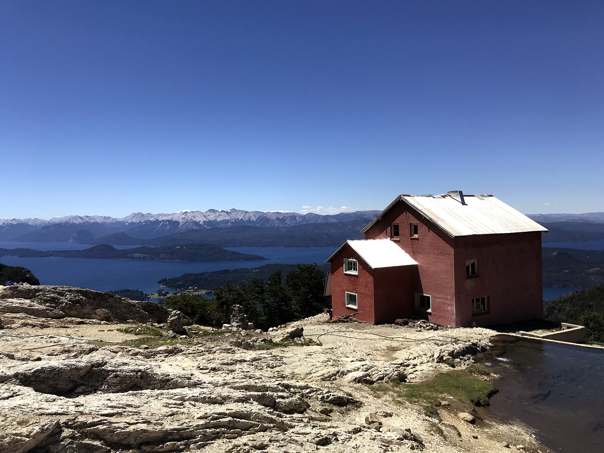 Red Refugio López on a rocky slope above Nahuel Huapi Lake