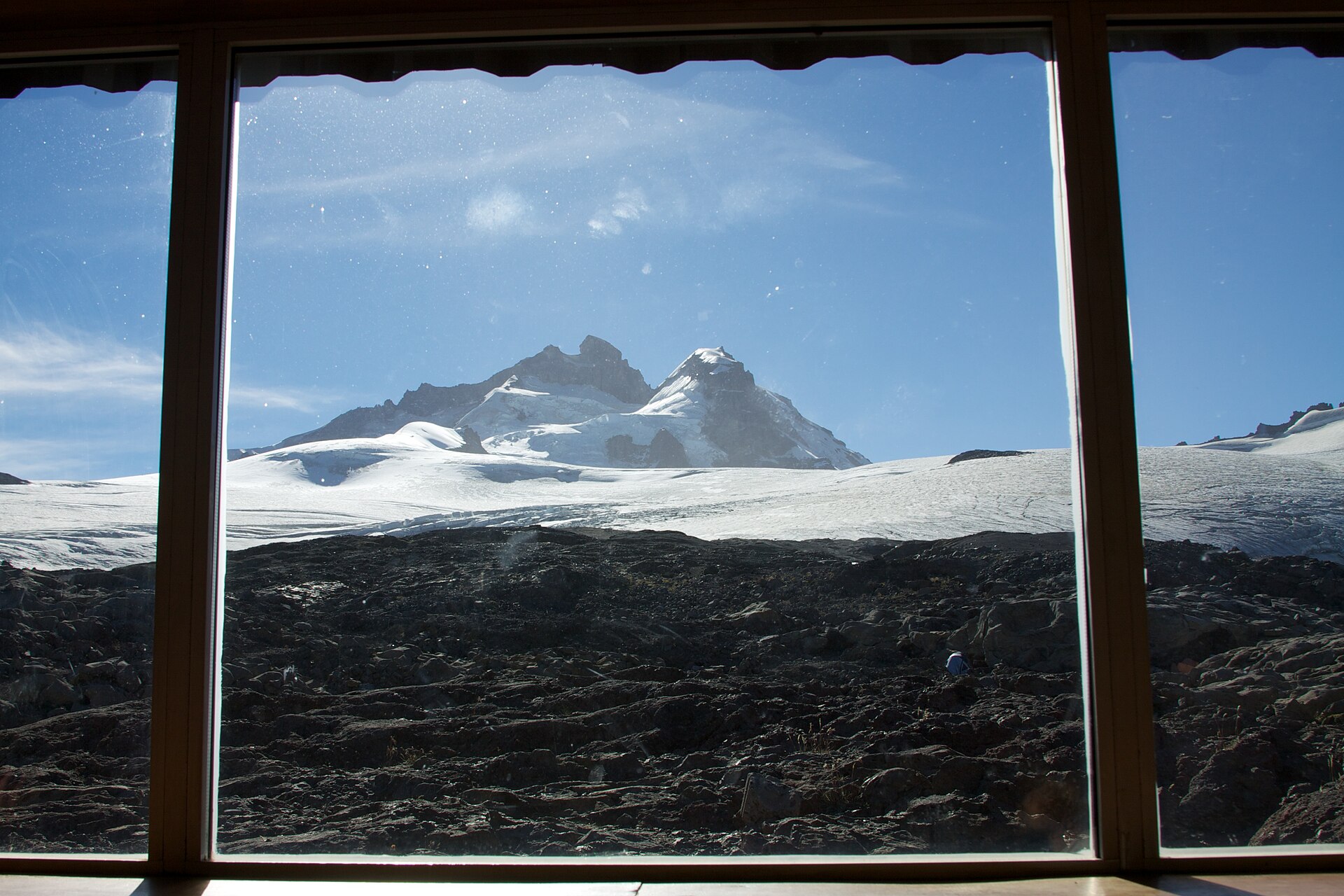 Cerro Tronador framed by the dark interior of a mountain-refuge window
