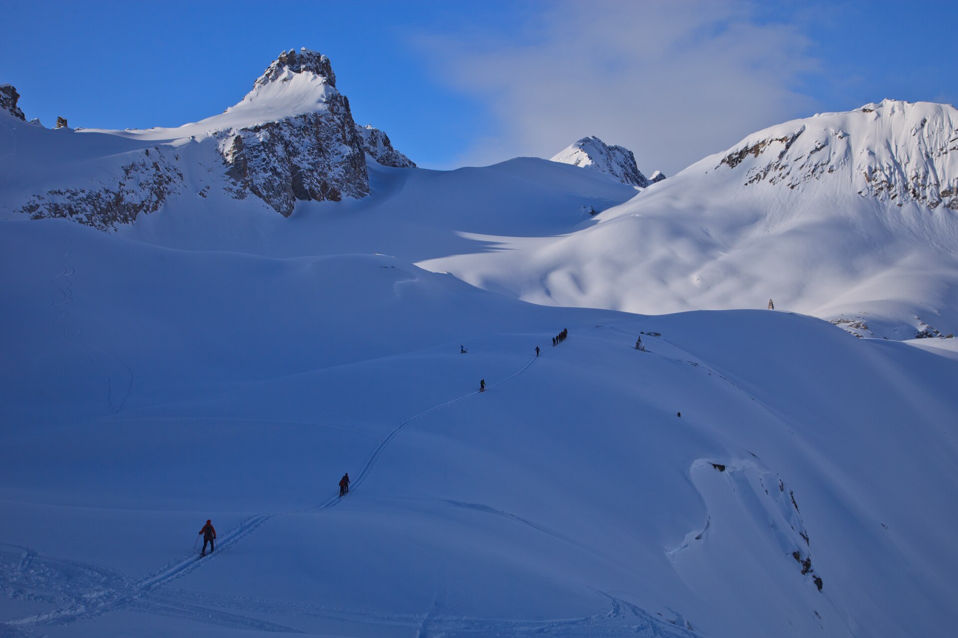 Ski tourers crossing a high snowy landscape in British Columbia