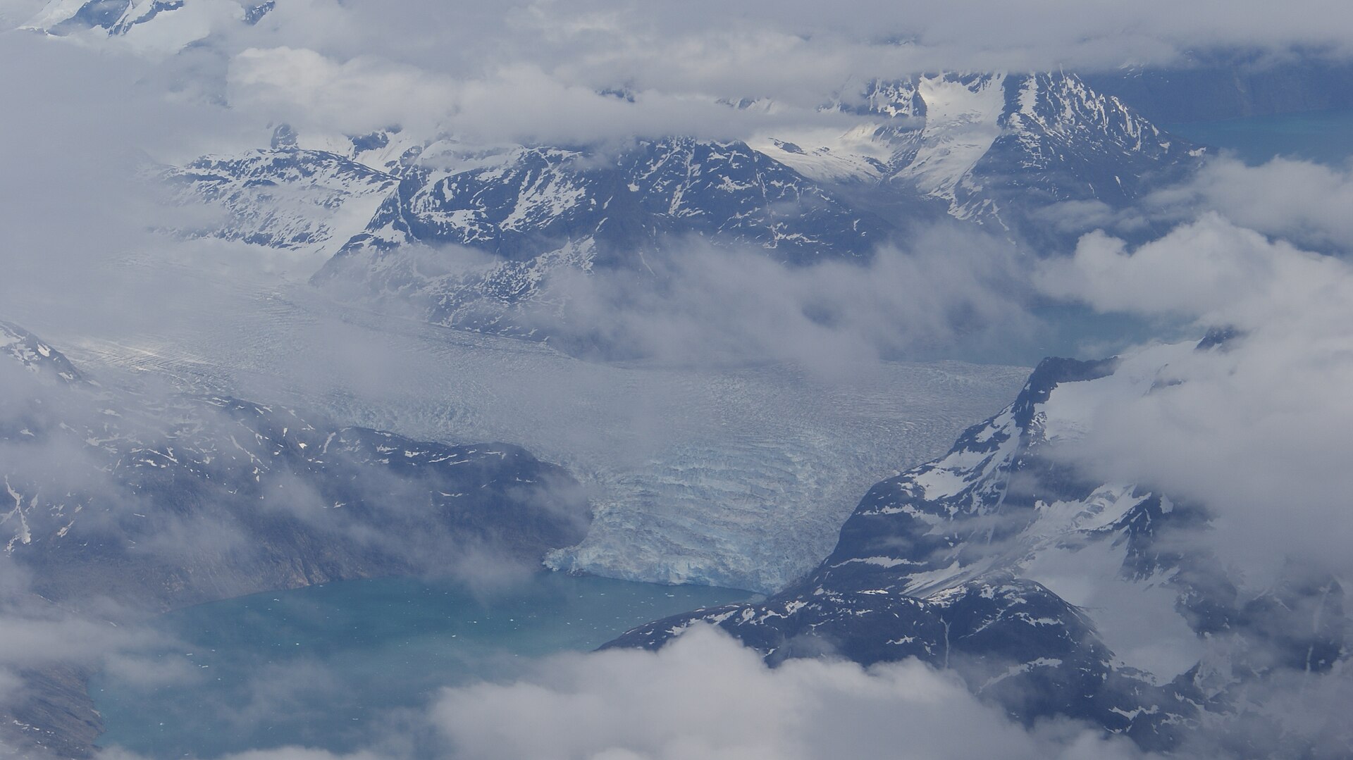 Aerial view of Sermitsiaq Glacier splitting between two West Greenland fjords