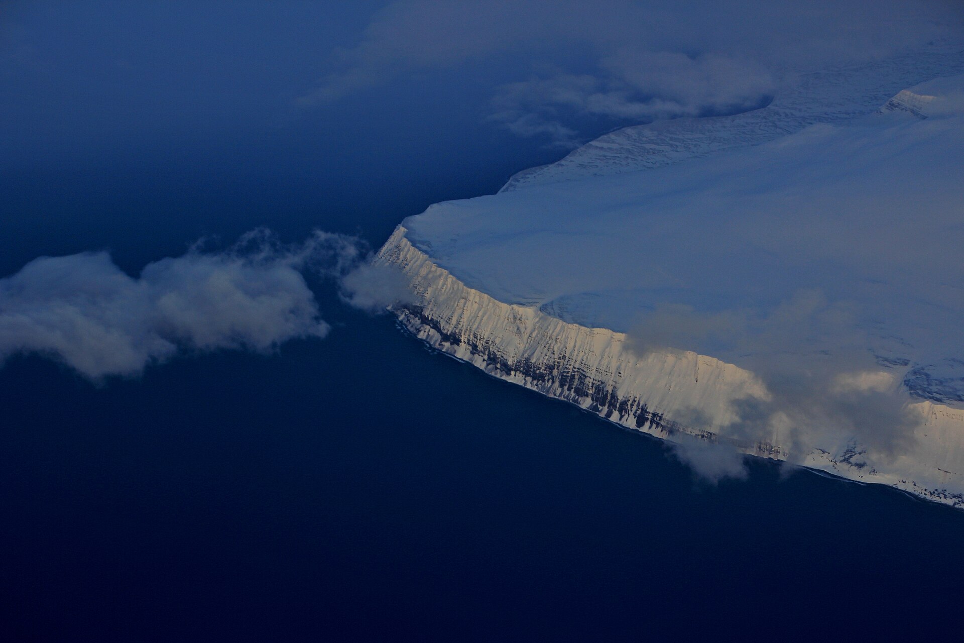 Aerial view of a snow-covered Westfjords plateau meeting the sea