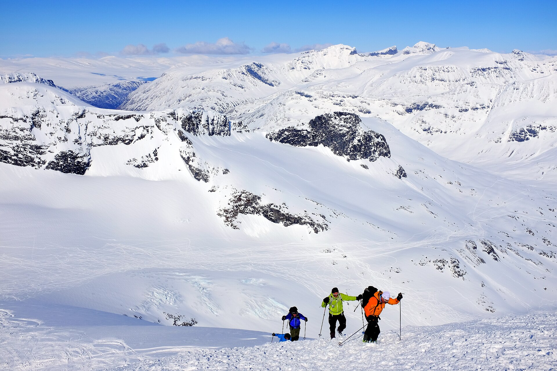 Ski tourers climbing Storebjørn above the glaciers of Jotunheimen