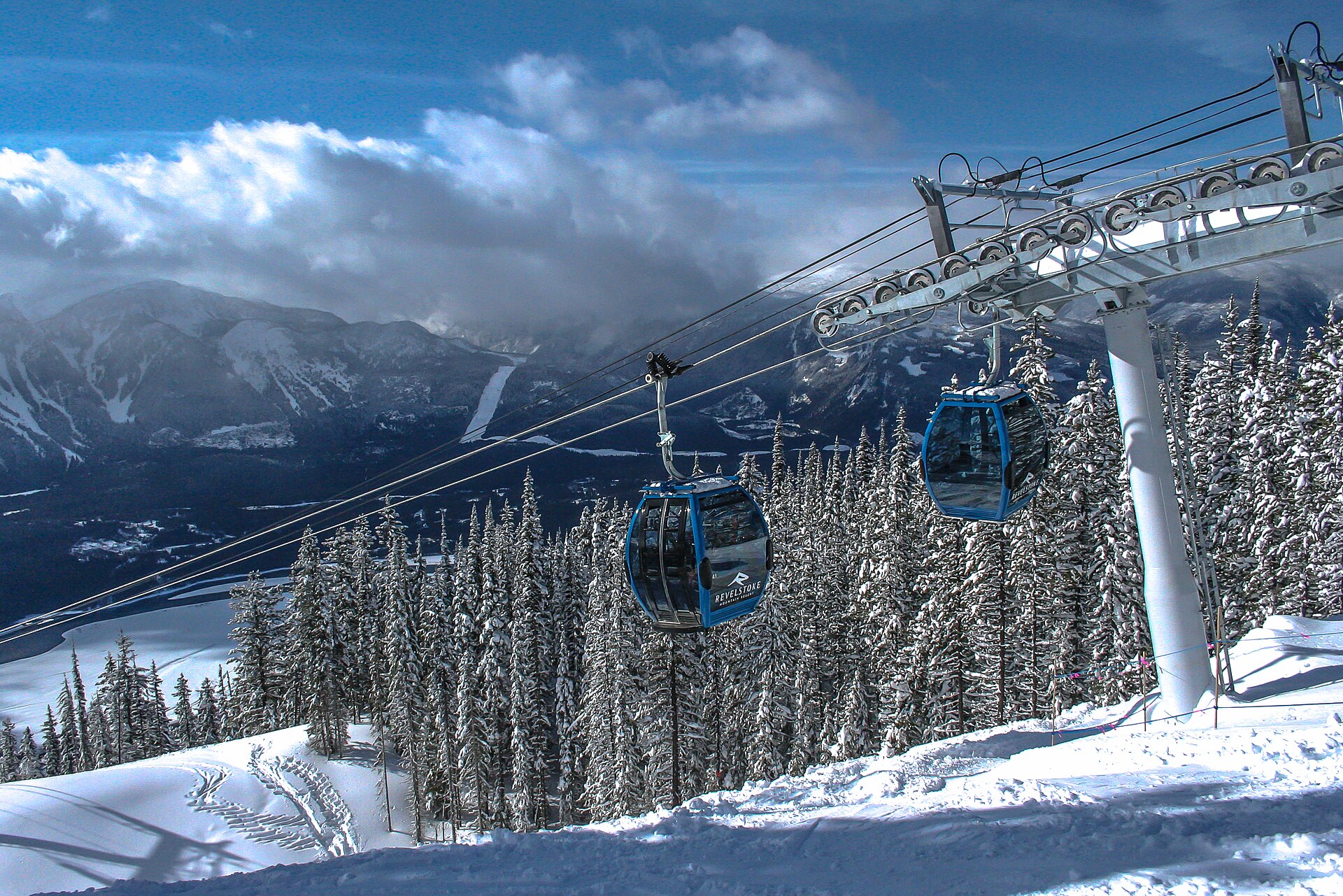 Revelstoke gondola above snowy forest with mountains beyond