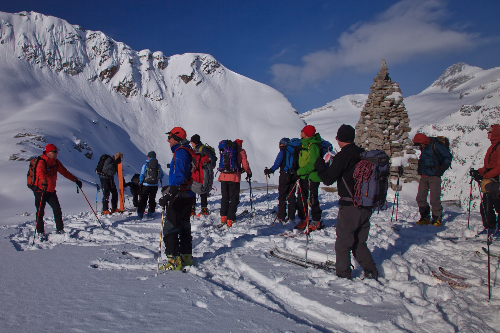 Ski tourers crossing a broad snowy Selkirk basin near Omoo Glacier