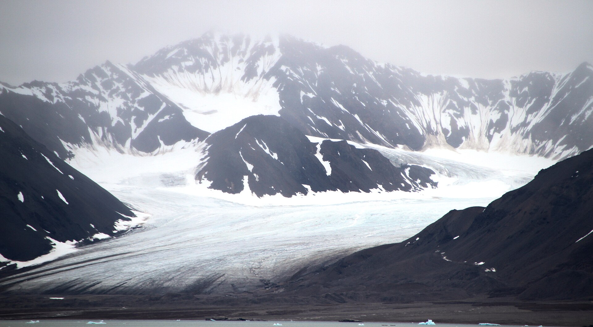Midtre Lovénbreen descending between sharp mountains towards Kongsfjorden