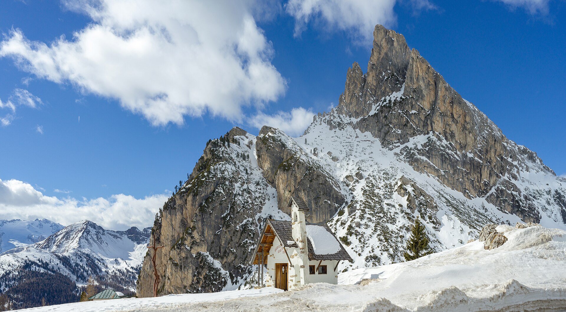The chapel at Passo Falzarego beneath snowy Sass de Stria