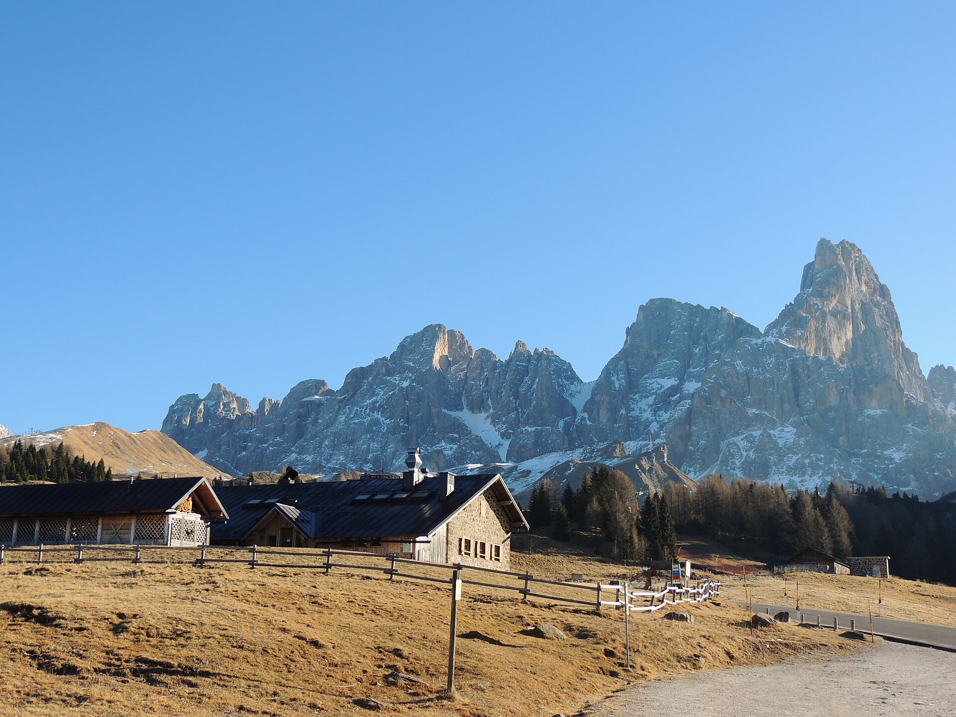 Cimon della Pala and the Pale di San Martino behind the buildings and open pasture of Passo Rolle