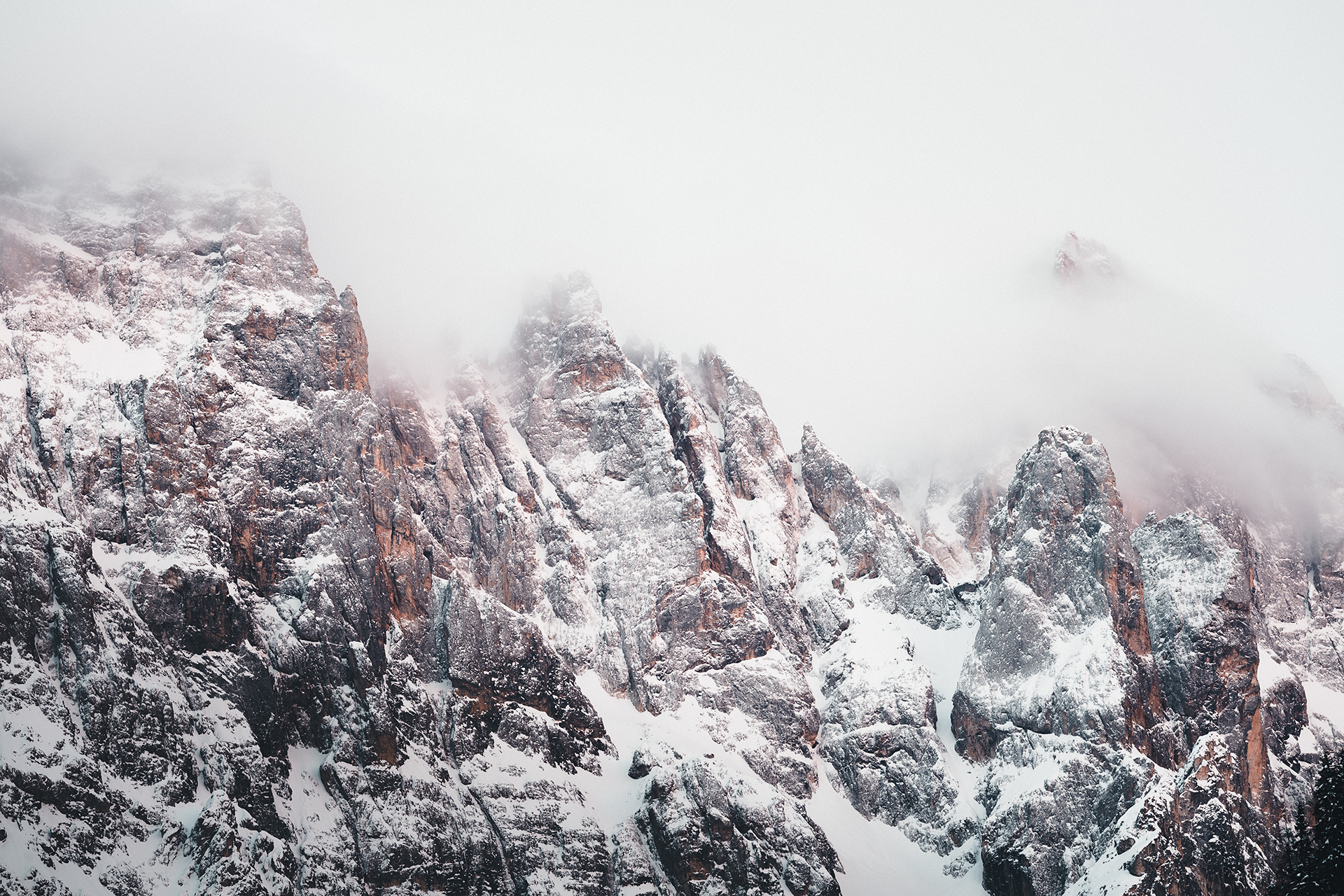 Snow-plastered rock towers and gullies of the Pale di San Martino disappearing into cloud