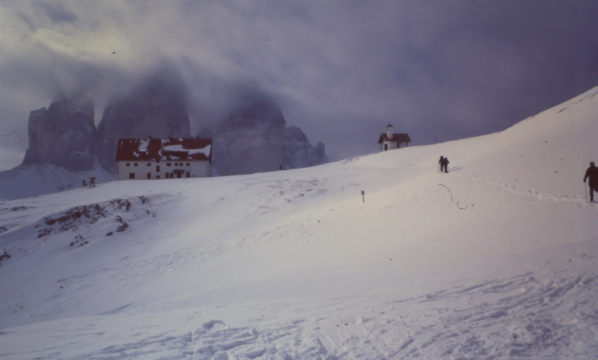 Tre Cime in winter cloud above the closed Locatelli hut