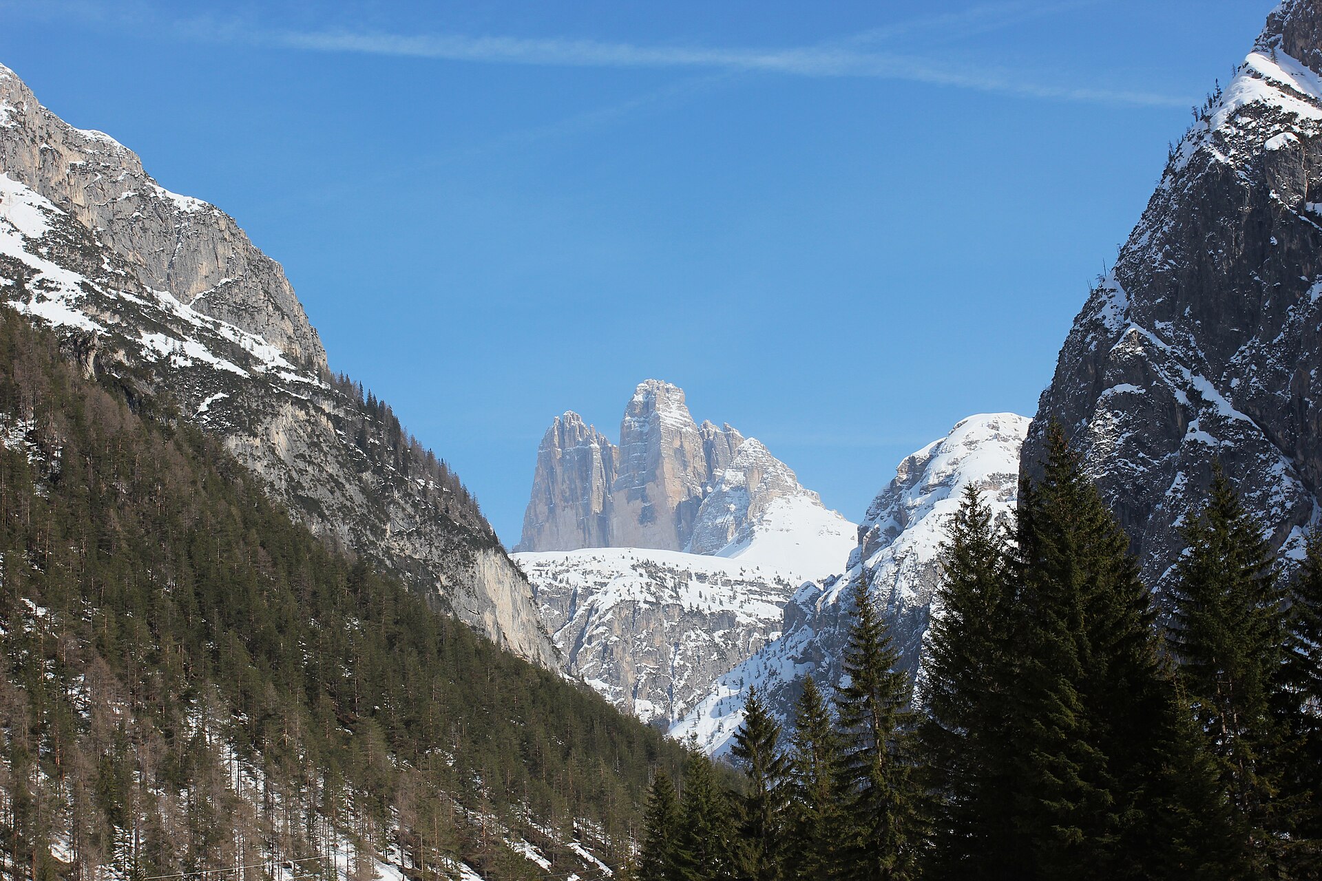 The three towers of Tre Cime above a broad field of spring snow