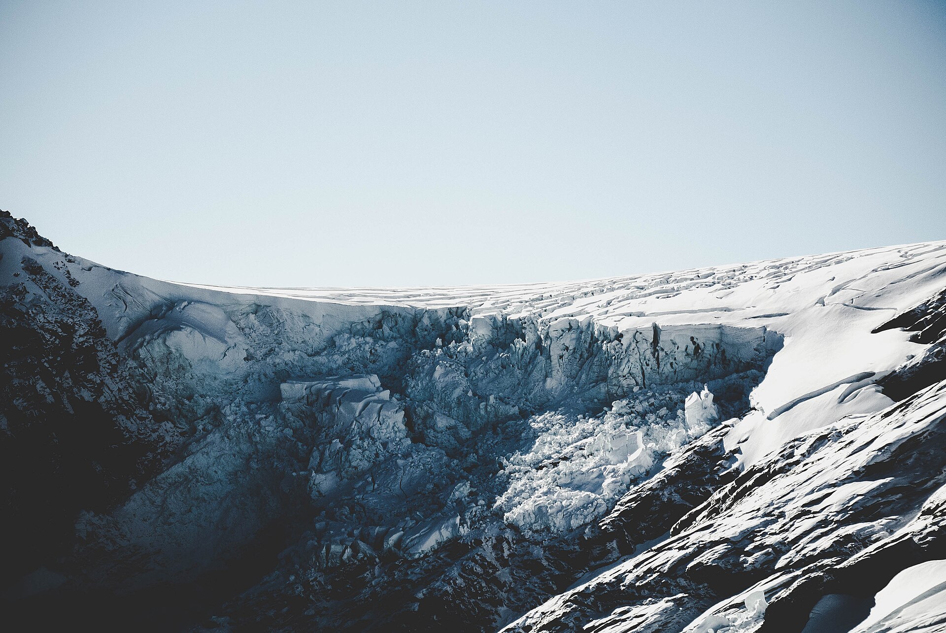 A broken glacier spilling over a dark cliff in Mount Aspiring National Park