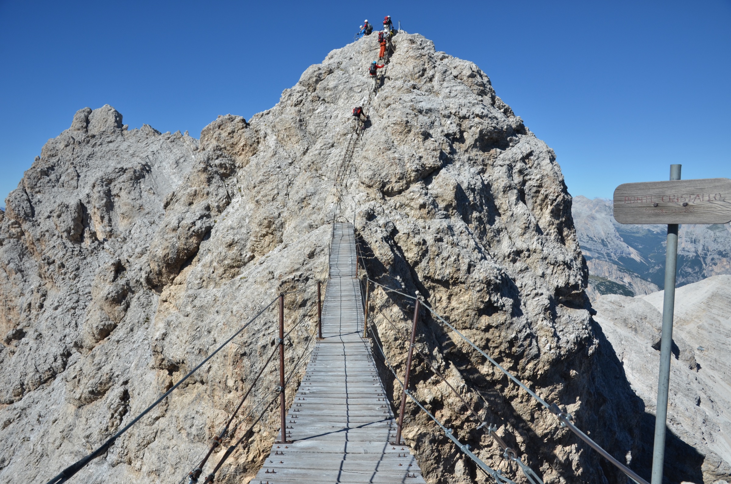 Climbers crossing the wooden-planked suspension bridge of the Via Ferrata Ivano Dibona in the Cristallo group, Dolomites