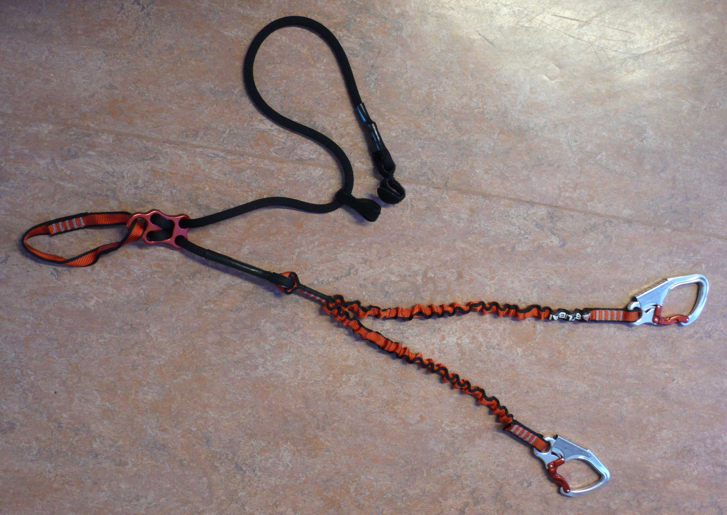 A modern Y-shaped via ferrata lanyard (Klettersteigset) with energy-absorbing arms and two self-locking carabiners