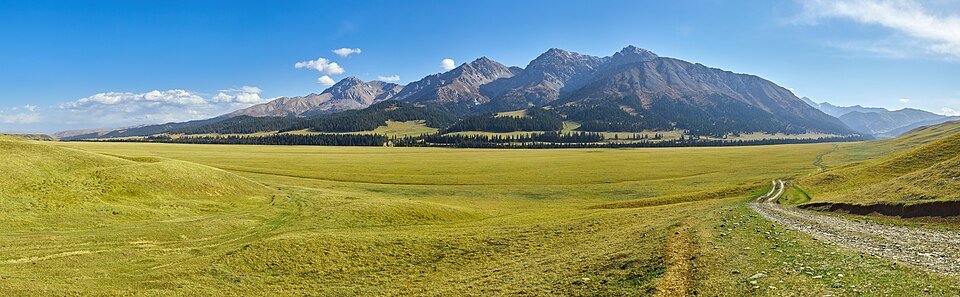 A broad alpine meadow and mountain ridge in nearby Kegen District