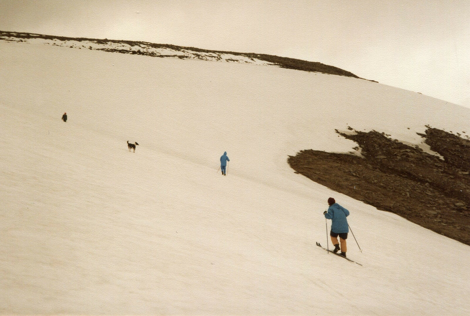 A skier crossing a narrow patch of old snow on Ben Macdui