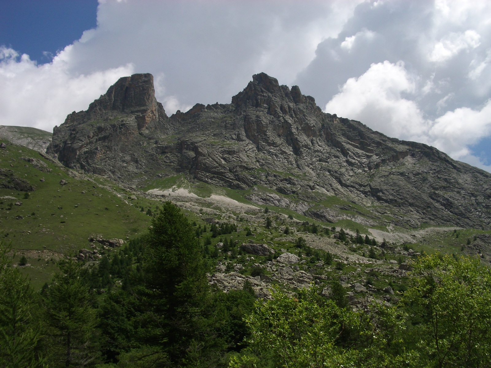 Sharp limestone formations above larch woods in Valle Maira