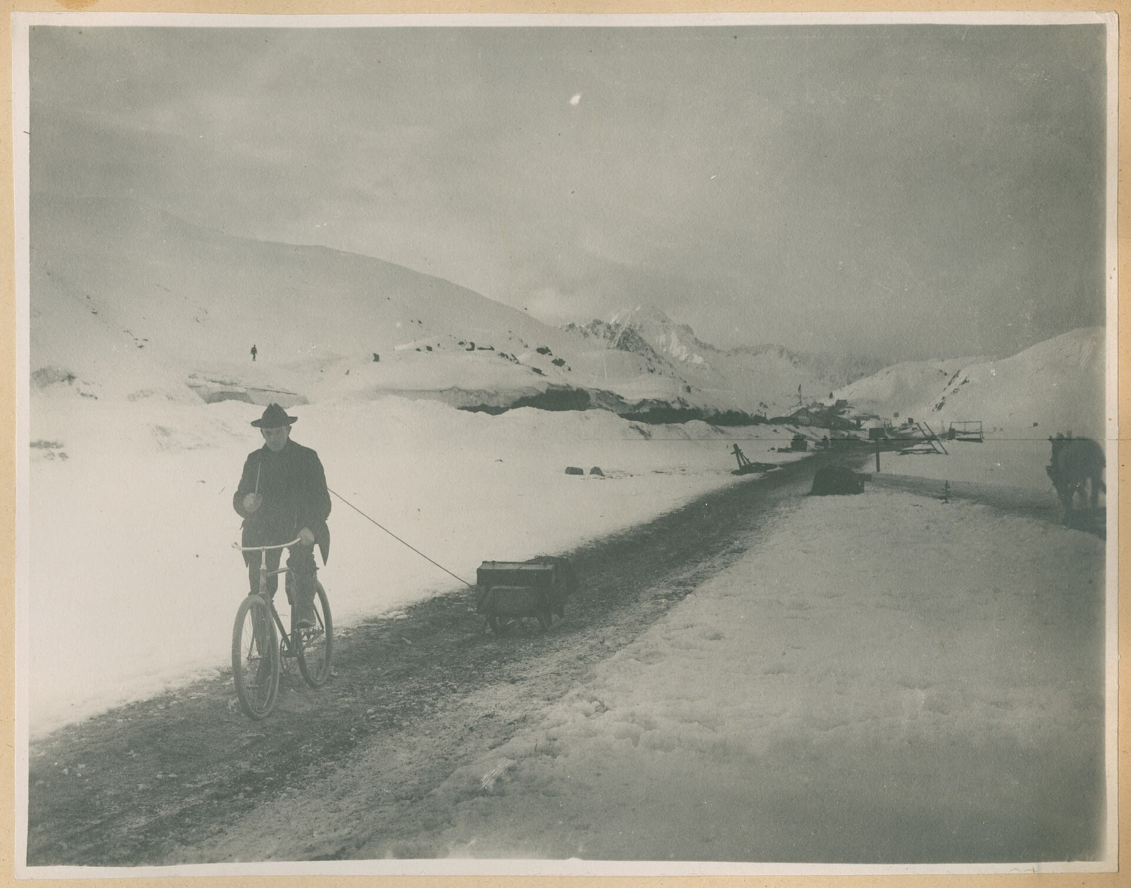A man with a bicycle pulling a sled near White Pass in 1899