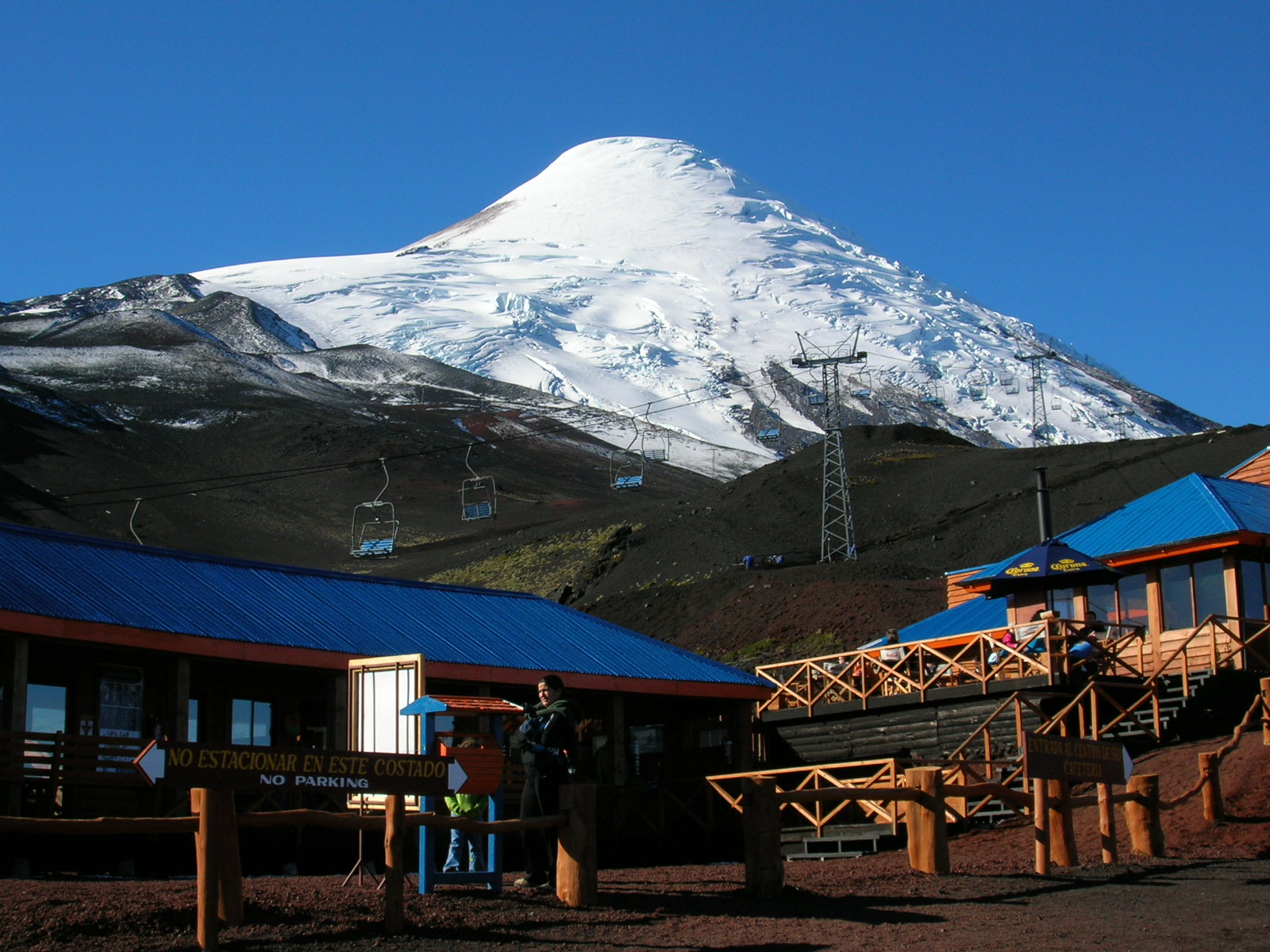 Snow-covered upper Osorno above the buildings and lifts of its mountain centre